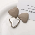 Detail of heart-shaped fabric buttons with ribbed texture on elegant white porcelain - Light Coffee