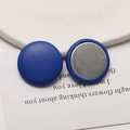 Detailed macro view of blue leather covered round buttons with a flat metal base finish - Blue