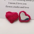 Macro detail of pink knitted heart charm with magnetic metal back on white background - Rose Red