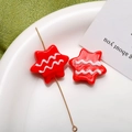 Close-up of red star-shaped glass beads with white wave patterns for DIY jewelry making - Star Style / 1 Piece (24mm)