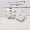 Detailed macro view of cream-colored flocked monster charms showing front and back DIY base - White One-Eyed Monster