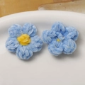 Detailed macro view of handmade light blue puff flower accessories with yellow centers - Blue Petal Yellow Core
