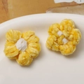 Macro shot of two yellow and white handmade crochet puff flower accessories on ceramic - Yellow Petal White Core
