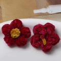 Close-up of handmade burgundy and yellow plush flower patches for DIY jewelry and crafts - Red Petal Yellow Core