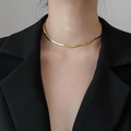 Close-up of minimalist gold snake bone chain necklace worn with a black v-neck blazer - Length 30+10cm / Gold