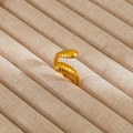 Primer plano de un anillo espiral dorado sobre un soporte de lino para joyas de diseño - Estilo de Envoltura Espiral (3)