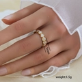 Detalle macro de anillo de corazón dorado de 5mm y 1,5g con incrustaciones blancas - Estilo de Banda de Corazón Envolvente