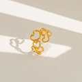 Dettaglio dell'anello aperto dorato con motivi a cuore traforati su sfondo bianco - Stile Avvolto da Cuore Traforato (11) / Oro