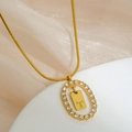 Gold snake chain necklace featuring a rhinestone letter T pendant on satin background - Letter T