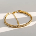 Detail van een gouden roestvrijstalen armband met zirkonia en een stevige karabijnsluiting - Wit