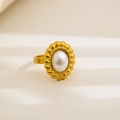 Detailed close-up of a vintage gold-plated ring with an oval pearl and wave engraving - Oval Artificial Pearl Wave Design / Gold