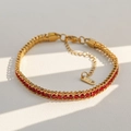Macro-opname van gouden roestvrijstalen ketting met rode kristallen en K18-label - Rood