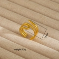 Detailed macro view of gold-plated multi-layer crossover open ring on a beige velvet tray - Gold Intertwined Streamline Style (84)