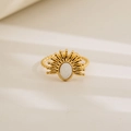 Macro shot of gold sunburst ring with white oval inlay and twisted rope band detail - Sunburst Oval Opal Look Design / Gold