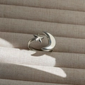 Primer plano de dijes de estrella y luna pulidos en un anillo ajustable minimalista - Estilo Plateado (293)