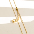 Dettaglio del ciondolo in oro 18K con perla e chiusura a moschettone su sfondo strutturato - Stile con Intarsio di Perle (2-18)