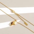 Dettaglio del ciondolo geometrico dorato con occhio di tigre e targhetta marchio MISS - Stile Rombo Occhio di Tigre (B56)