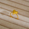 Dettaglio dell'anello a cuore dorato con fascia a corda su espositore in lino beige - Stile Cuore Intrecciato (142)