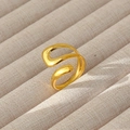 Dettaglio dell'anello a onda minimalista placcato oro 18k su espositore per gioielli beige - Stile Ondulato Minimalista Essenziale (104)