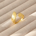 Dettaglio anello a piuma dorata con incisioni fini su espositore in velluto beige - Stile Aperto Piuma Vintage (114)
