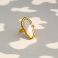 Detalle macro de anillo geométrico dorado con esmalte blanco y forma orgánica irregular - Estilo Textura Nácar Blanca Irregular Estilo Arte Moderno (419)