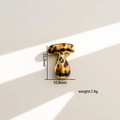 Detalle del colgante letra T dorado con estampado de leopardo y medidas de 23,2mm - Letra T