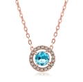 Detailed macro of a rose gold circular pendant with a centered blue zircon and halo diamonds - Rose Gold With Aquamarine Stone