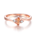 Rose gold ring with marquise-cut orange zircon and circular clear stones on white background - Rose Gold Color - Champagne Zirconia