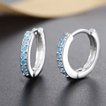 Macro detail of silver hoop earrings featuring micro-set sky blue cubic zirconia - White Gold With Blue Zircon