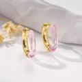 Close-up of gold-plated hoop earrings with pink acrylic resin on fabric background - Light Pink