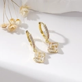 Elegant gold earrings with sparkling zircon pendant on a white surface, professional jewelry shot - Gold Square / Gold