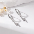 Detail of silver lightning bolt earrings with clear cubic zirconia on a white stone - Lightning Pendant Style / Silver