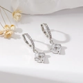 Detailed close-up of silver earrings with rectangular zircon stones on a white stand - Silver Square / Silver