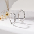 Vue détaillée des créoles en argent avec une surface texturée à effet martelé unique - Argent Grand Martelé