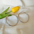 Polished silver hoop earrings with 925 silver needle on white textured fabric background - 6cm / Silver