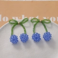 Detail of handmade beaded cherry hair clip with teal crystal beads and bow accent - Blue