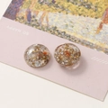 Macro shot of circular resin charm with gold and silver foils for DIY jewelry making - No.2 Orange Dried Flower