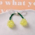 Vista detallada del accesorio de cereza hecho a mano con perlas blancas y cuentas de resina - Amarillo