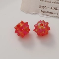 Macro shot of matte orange-pink gradient acrylic urchin bead with detailed spikes and hole - Matte Red
