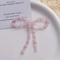 Detailed macro view of pink crystal beaded bow jewelry on elegant white decor plate - Pink