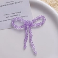Macro shot of handcrafted purple crystal beaded bow with dangling bead chains detail - Purple