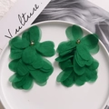 Detailed macro view of deep green multi-layered organza flower earrings on ceramic plate - Green