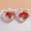 Detailed close-up of heart-shaped resin charms with red dried flowers and white pearls - Orange Red Dried Flowers