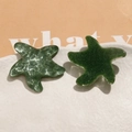Macro detail of green glitter resin and hammered metal starfish charms on ceramic - Green One (B53-4-14-19)
