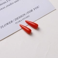 Detail view of two shiny red resin cone pendants for DIY jewelry making accessories - Orange Marble