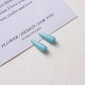 Macro view of light blue resin teardrop pendants for DIY jewelry and earring making - Blue-Green