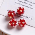 Macro detail of red faceted glass bead spheres with iridescent flower sequins for jewelry - Red
