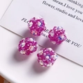 Close-up of handmade pink beaded flower charms with iridescent sequins for DIY jewelry - Purple