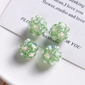 Macro view of handmade green glass beaded floral balls for DIY jewelry and hair accessories - Green