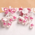 Close-up of handmade pink ribbon bow with hanging transparent beads and matte finish charms - Rose Red